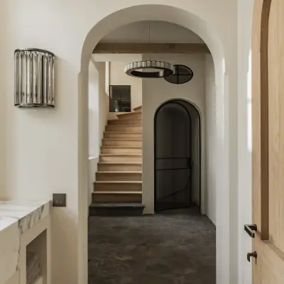 Gang met boogdoorgang, kristallen wandlamp en een trap met houten treden, Hoeve in Westkapelle, interieur Laura Calleeuw