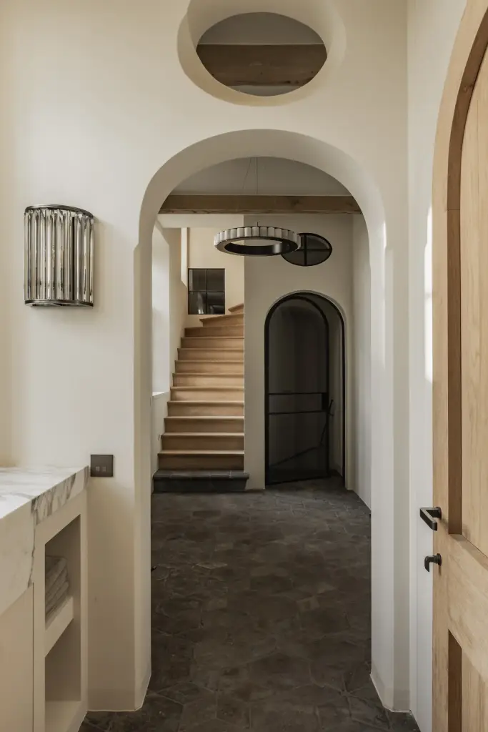 Gang met boogdoorgang, kristallen wandlamp en een trap met houten treden, Hoeve in Westkapelle, interieur Laura Calleeuw