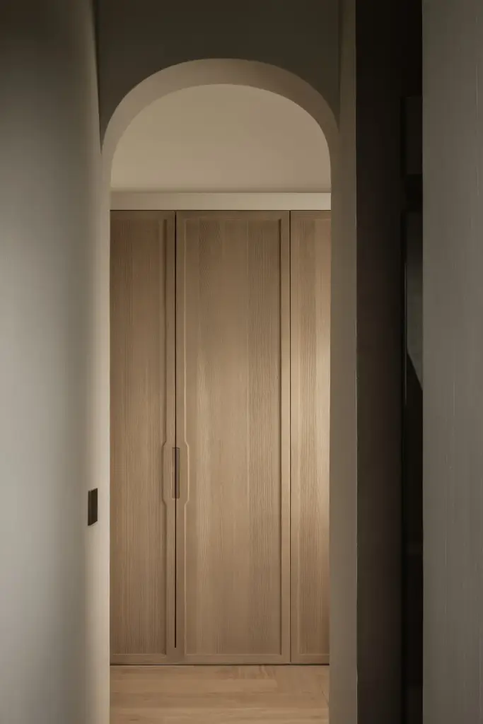 Boogdoorgang naar een garderobe met kasten in eikenhout, Hoeve in Westkapelle, interieur Laura Calleeuw