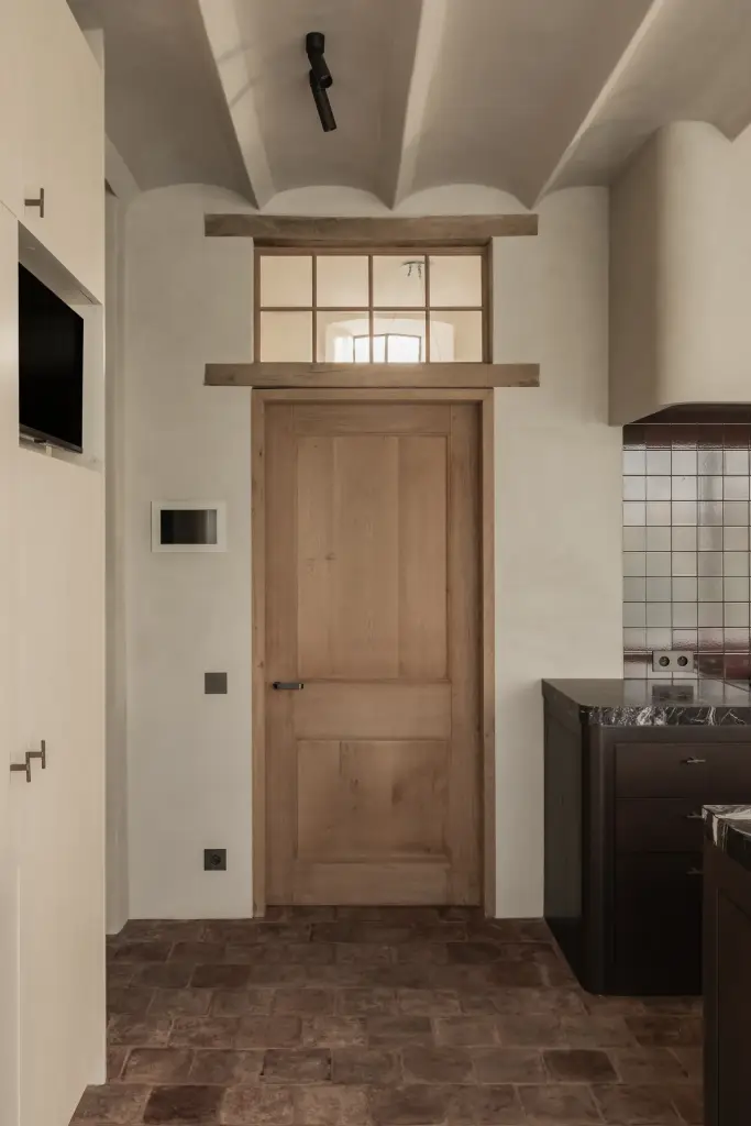 Eikenhouten deur met bovenlicht naast de keuken met tegelwerk, Hoeve in Westkapelle, interieur Laura Calleeuw