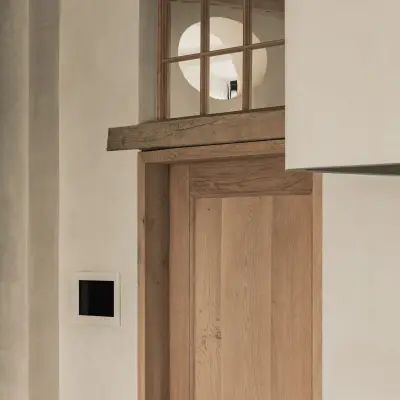Houten deur onder een ronde lichtopening en een houten latei, Hoeve in Westkapelle, interieur Laura Calleeuw