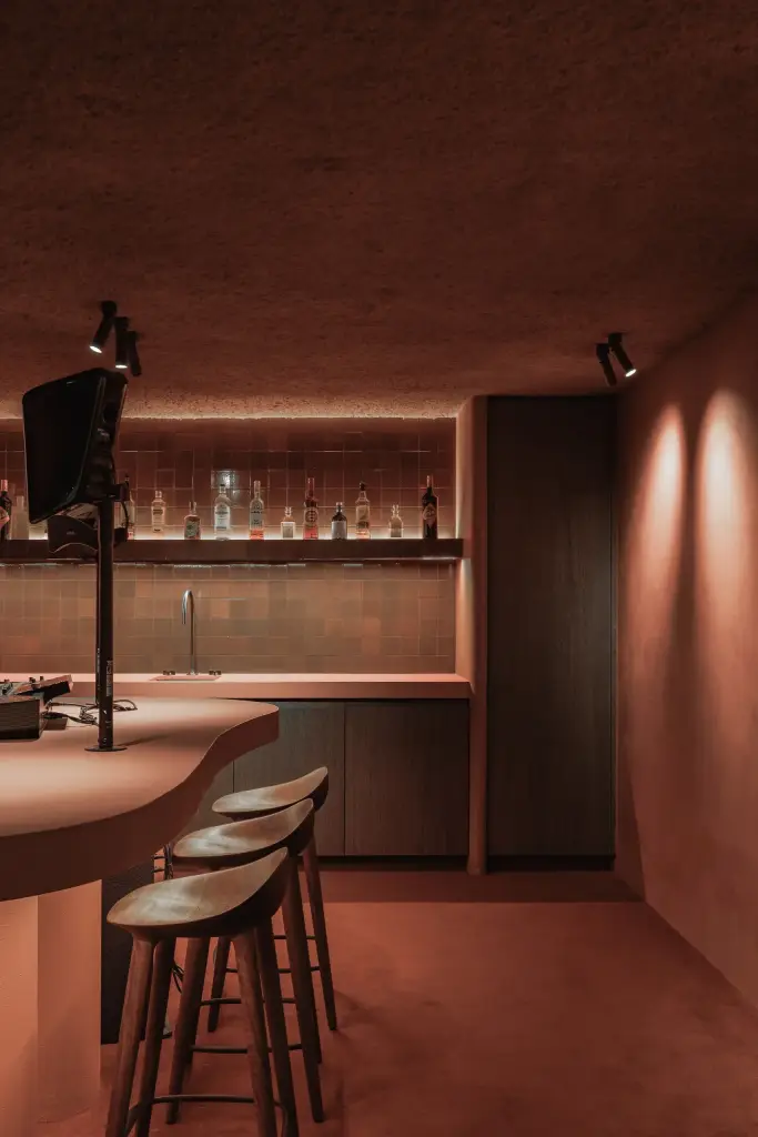 Kelderbar met toog, barkrukken, televisie en flessenwand, Hoeve in Westkapelle, interieur Laura Calleeuw
