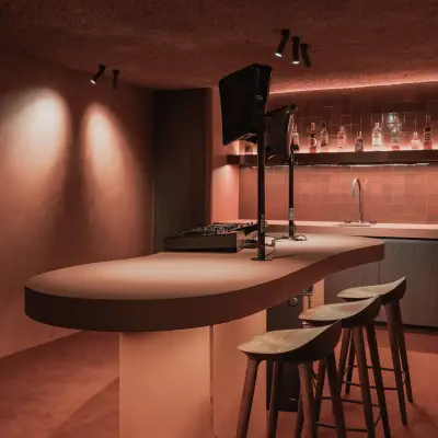 Kelderbar met halfronde toog, houten krukken en spots, Hoeve in Westkapelle, interieur Laura Calleeuw