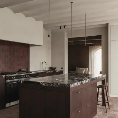 Keuken met kookeiland in donker hout met rood marmer en een terracotta vloer, Hoeve in Westkapelle, interieur Laura Calleeuw