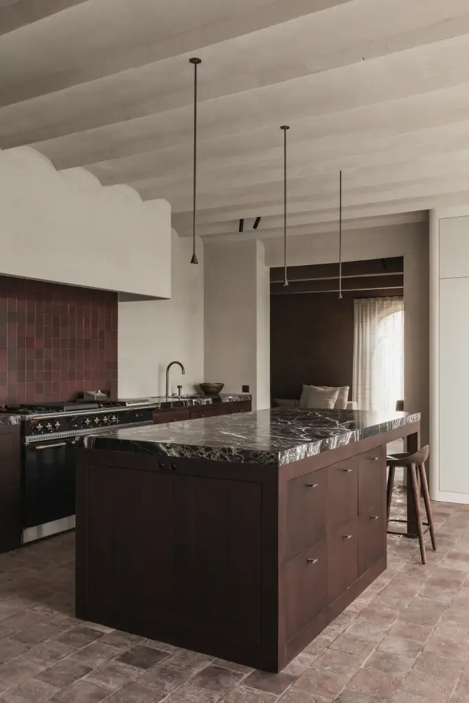 Keuken met kookeiland in donker hout met rood marmer en een terracotta vloer, Hoeve in Westkapelle, interieur Laura Calleeuw