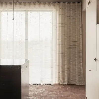 Kookeiland voor een raam met vitrage op een terracotta vloer, Hoeve in Westkapelle, interieur Laura Calleeuw