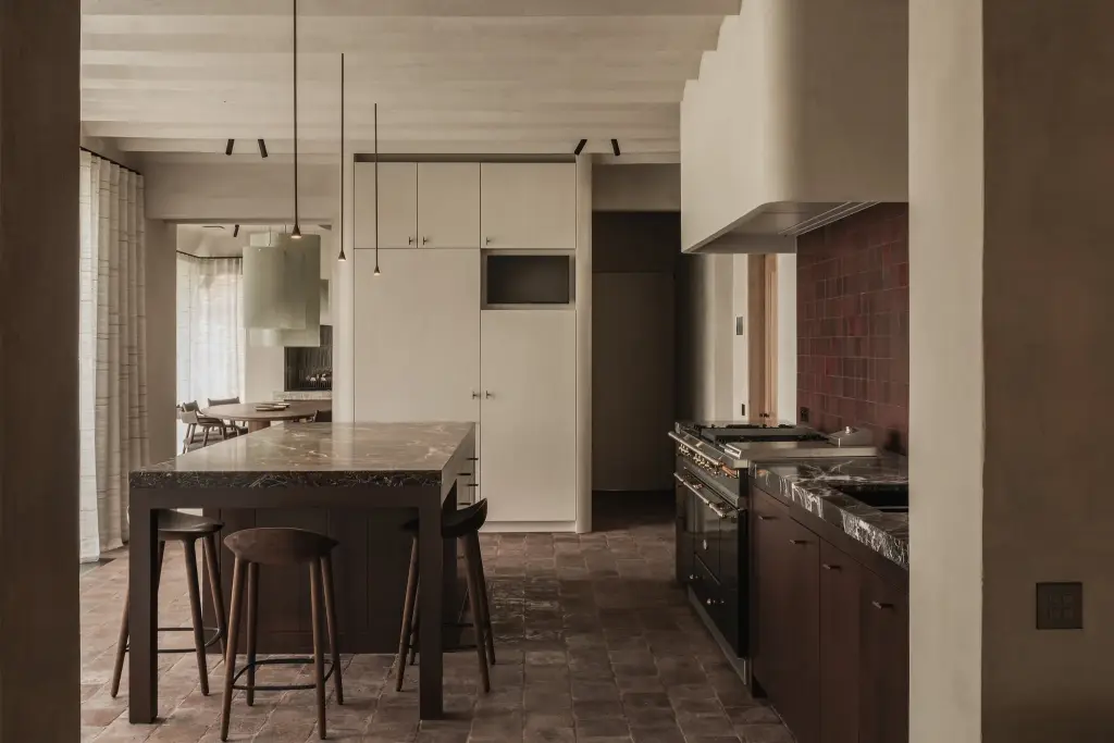 Keuken met kookeiland met zitplaatsen, rode tegels en een lichtgroene hanglamp, Hoeve in Westkapelle, interieur Laura Calleeuw