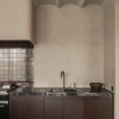 Keuken met spoelbak, kraan, metaalkleurig tegelwerk en een ronde gepleisterde schouw, Hoeve in Westkapelle, interieur Laura Calleeuw