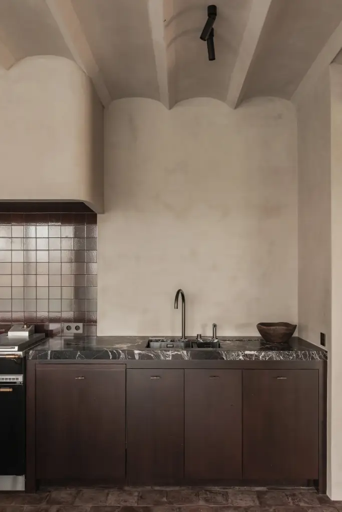 Keuken met spoelbak, kraan, metaalkleurig tegelwerk en een ronde gepleisterde schouw, Hoeve in Westkapelle, interieur Laura Calleeuw