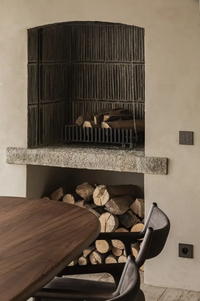 Open haard met zwarte ribbelwand, houtstapel en een granieten latei, Hoeve in Westkapelle, interieur Laura Calleeuw