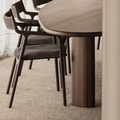 Ovale houten eettafel met ronde poot, stoelen en een wollen tapijt, Hoeve in Westkapelle, interieur Laura Calleeuw