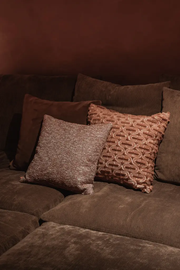 Kussens met patroon op de sofa in de thuisbioscoop, Hoeve in Westkapelle, interieur Laura Calleeuw