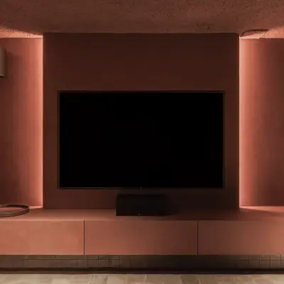 Televisie boven een zwevend terracotta meubel tussen fluwelen gordijnen, Hoeve in Westkapelle, interieur Laura Calleeuw