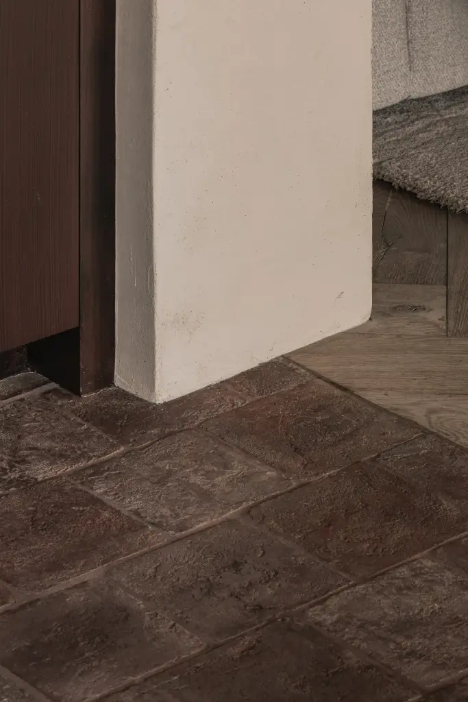 Detail van een terracotta vloer en een gepleisterde hoek, Hoeve in Westkapelle, interieur Laura Calleeuw