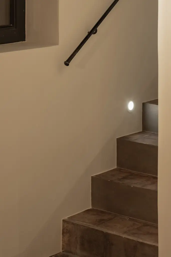 Trap met zwarte leuning en ingewerkt licht langs de treden, Hoeve in Westkapelle, interieur Laura Calleeuw