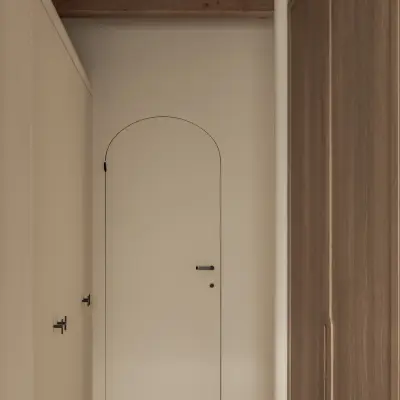 Witte boogdeur naast een kastenwand in eikenhout, Hoeve in Westkapelle, interieur Laura Calleeuw