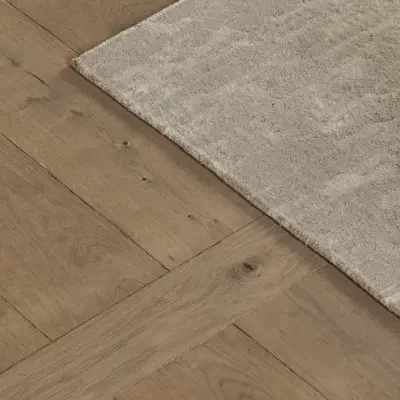 Detail van een wollen tapijt op visgraatparket, Hoeve in Westkapelle, interieur Laura Calleeuw