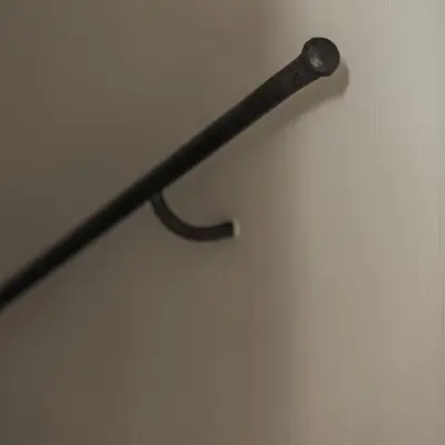 Detail van een zwarte trapleuning aan een gepleisterde wand, Hoeve in Westkapelle, interieur Laura Calleeuw