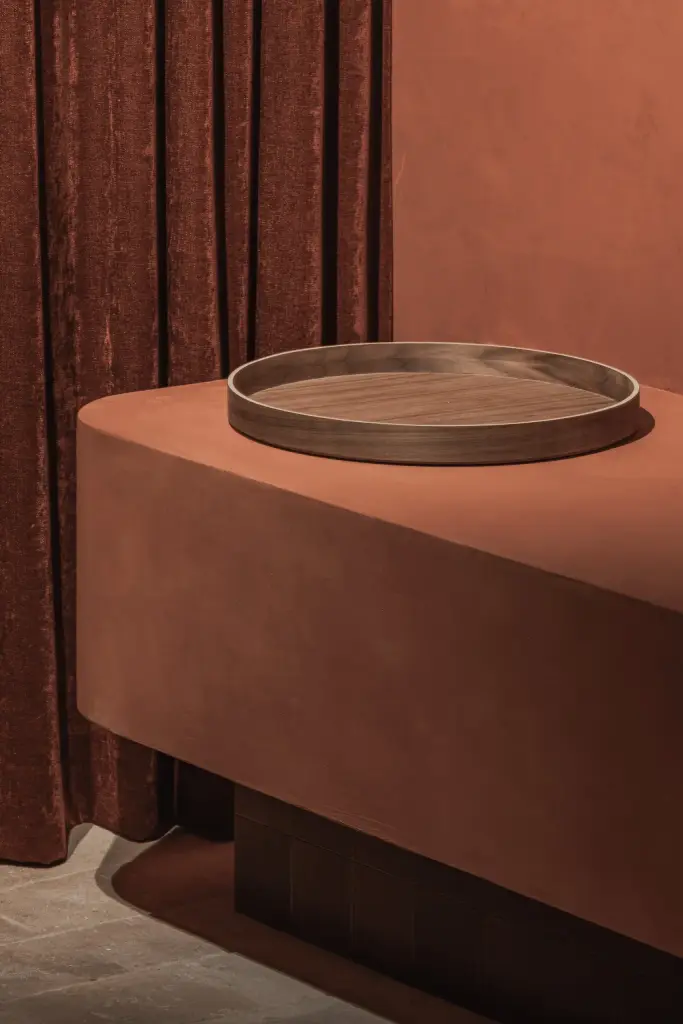 Zwevend terracotta meubel met een houten schaal naast het gordijn, Hoeve in Westkapelle, interieur Laura Calleeuw