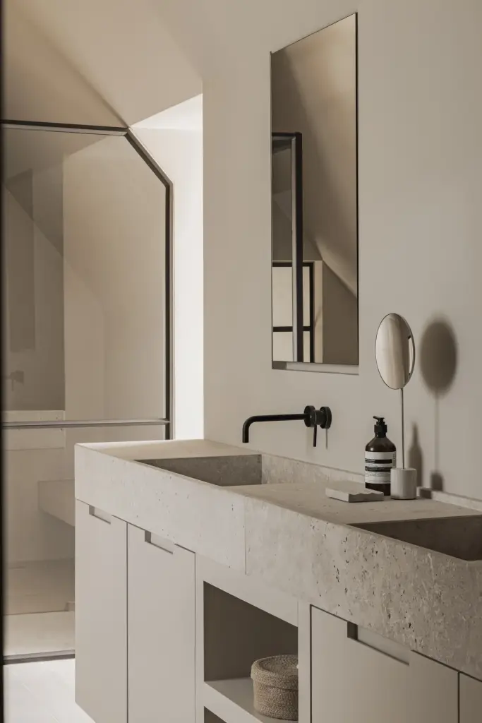 Wastafel in natuursteen met wandkraan, spiegel en open onderkast, a masterful balance between authenticity and comfort, interieur Laura Calleeuw
