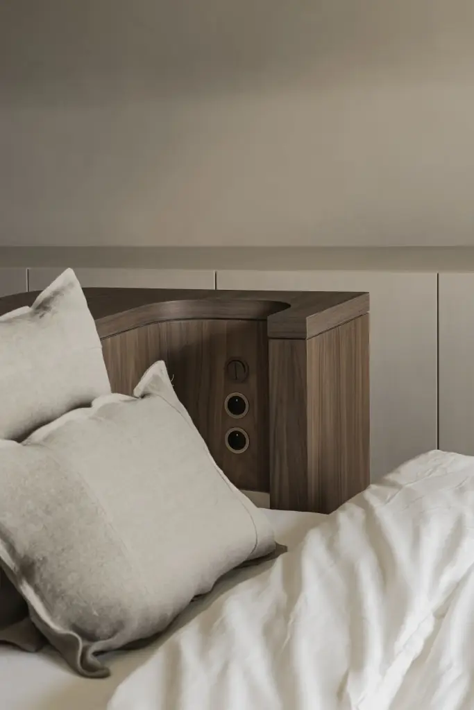 Bed met linnen kussens en notelaren nachtkastje met stopcontacten, a masterful balance between authenticity and comfort, interieur Laura Calleeuw