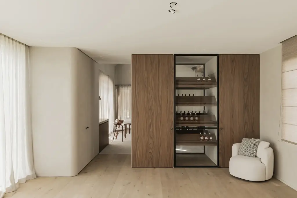 Doorkijk met wijnkast in staal en glas, fauteuil in bouclé en vitrage, a masterful balance between authenticity and comfort, interieur Laura Calleeuw