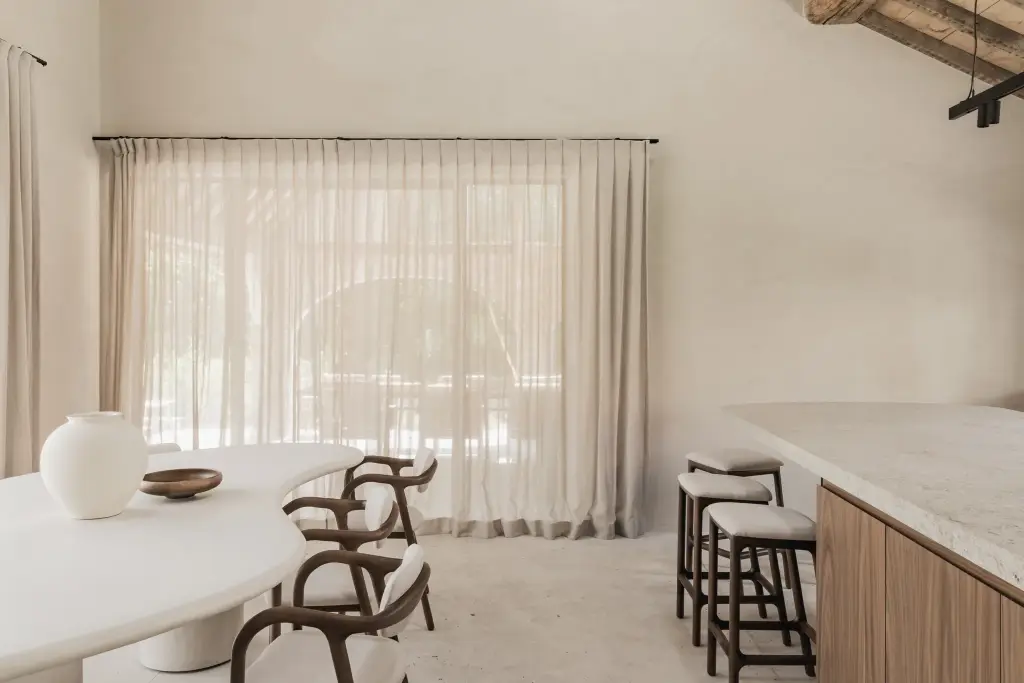 Eethoek met organische witte tafel, houten stoelen, krukken en vitrage, a masterful balance between authenticity and comfort, interieur Laura Calleeuw