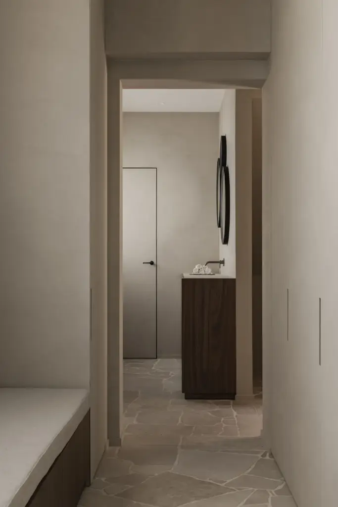 Gang met zitbank en doorkijk naar het wastafelmeubel en de vlakke deur, a masterful balance between authenticity and comfort, interieur Laura Calleeuw