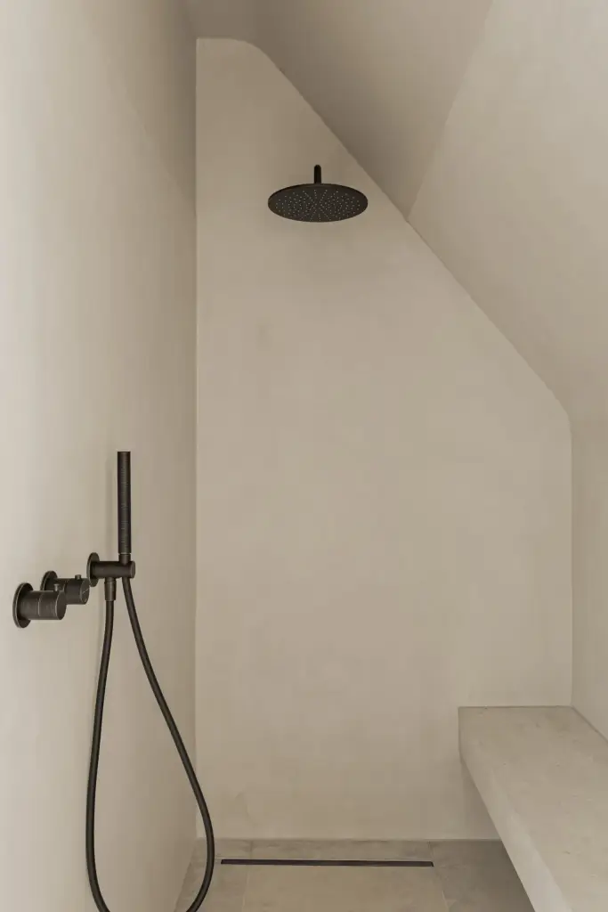 Inloopdouche met zwarte regendouche, handdouche en een ingebouwde zitbank, a masterful balance between authenticity and comfort, interieur Laura Calleeuw