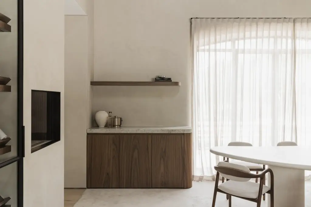 Notelaren onderkast met schap en televisie naast de eettafel en een raam met vitrage, a masterful balance between authenticity and comfort, interieur Laura Calleeuw