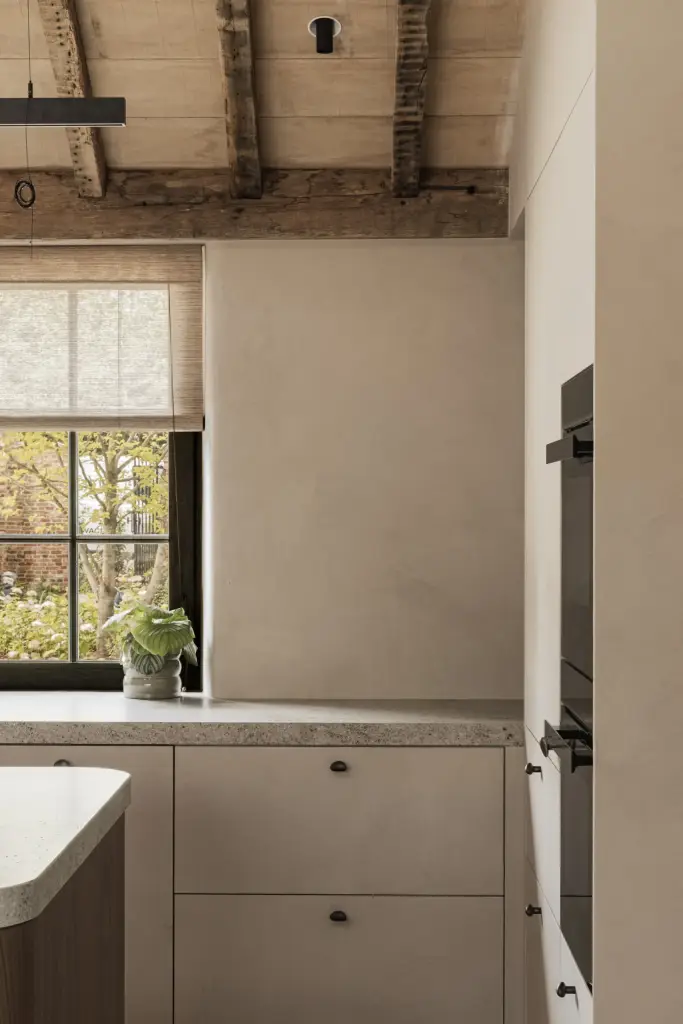 Keukenkasten met inbouwoven en een zwart raam met roman blind, a masterful balance between authenticity and comfort, interieur Laura Calleeuw
