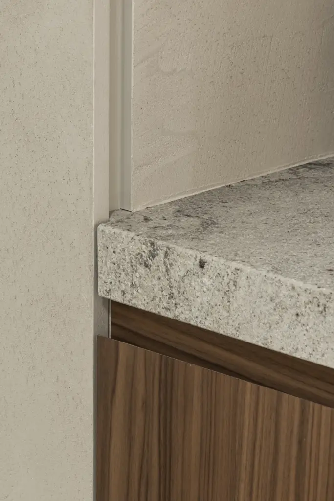 Detail van het natuurstenen blad boven een notelaren kast naast een stalen glasdeur, a masterful balance between authenticity and comfort, interieur Laura Calleeuw