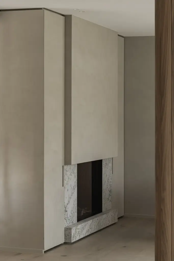 Open haard in witte natuursteen onder een gepleisterd volume, a masterful balance between authenticity and comfort, interieur Laura Calleeuw