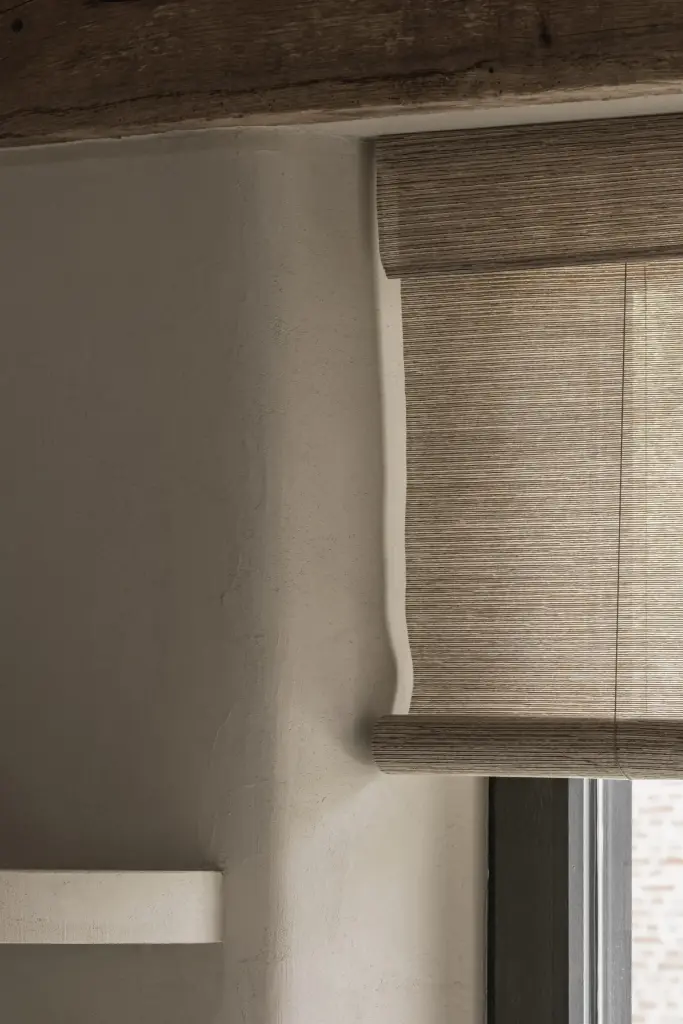 Rieten roman blind in een gepleisterde raamnis, a masterful balance between authenticity and comfort, interieur Laura Calleeuw
