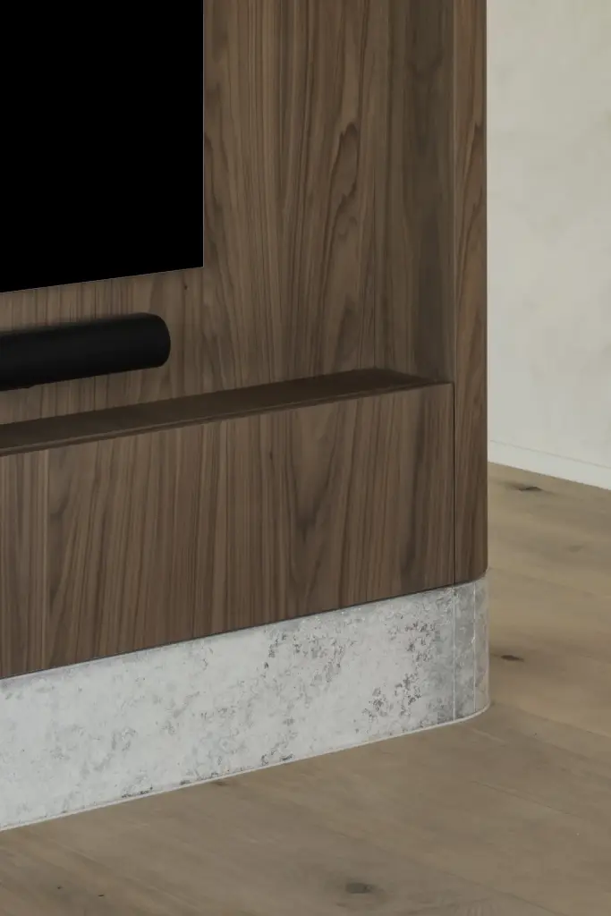 Detail van het notelaren paneel met televisie, soundbar en natuurstenen plint, a masterful balance between authenticity and comfort, interieur Laura Calleeuw