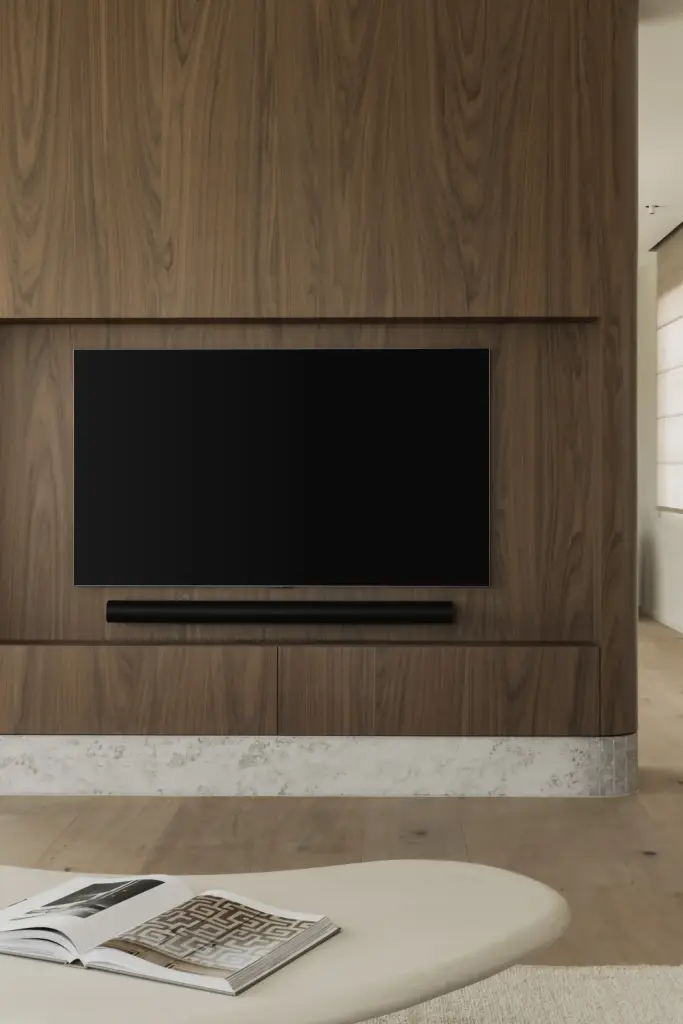 Televisiepaneel in notelaar en de salontafel met tijdschriften, a masterful balance between authenticity and comfort, interieur Laura Calleeuw