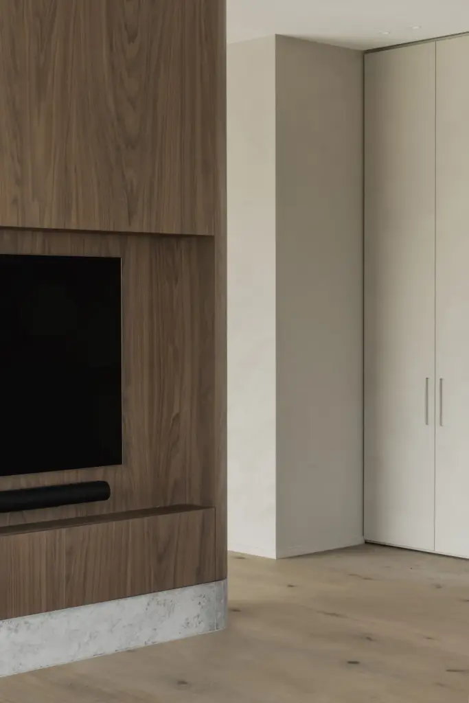 Televisienis in notelaar naast witte kastdeuren, a masterful balance between authenticity and comfort, interieur Laura Calleeuw