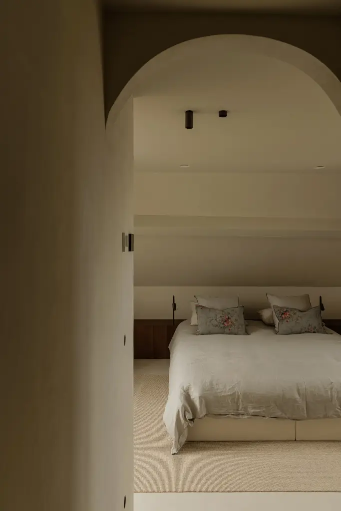 Boogopening met doorkijk naar de slaapkamer en het bed, Villarenovatie in Knokke, interieur Laura Calleeuw