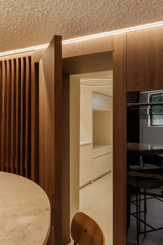 Doorkijk door de lamellenkast van de eetnis naar de witte keuken, Villarenovatie in Knokke, interieur Laura Calleeuw