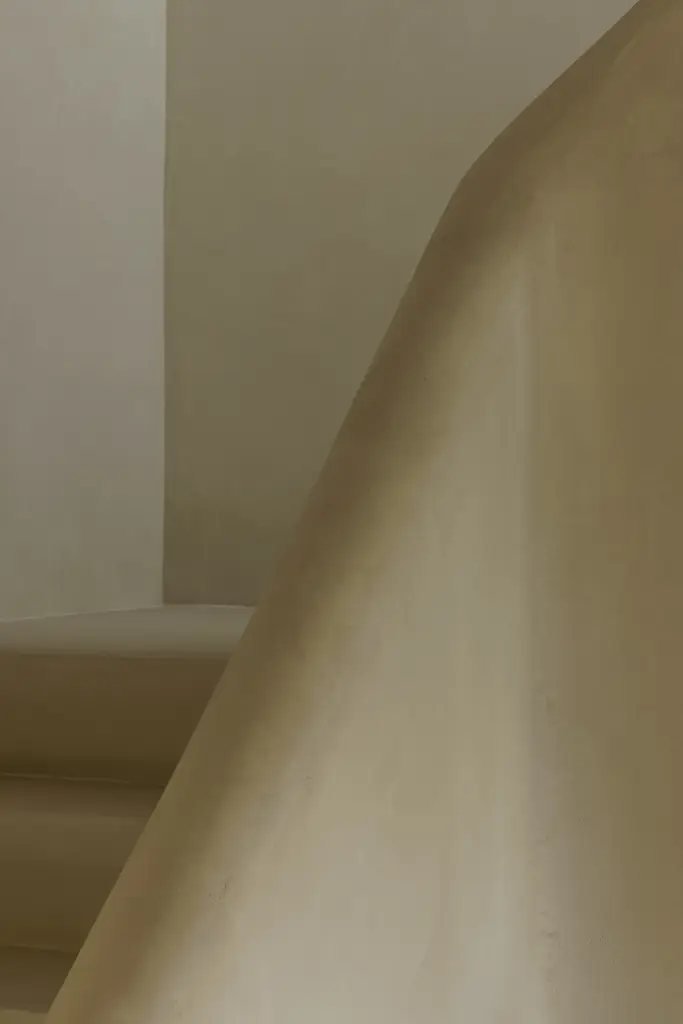 Detail van de gepleisterde trap en leuning in kalkpleister, Villarenovatie in Knokke, interieur Laura Calleeuw