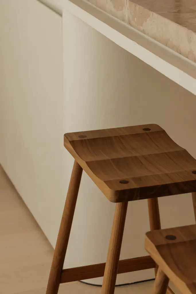 Houten kruk onder een natuurstenen blad, Villarenovatie in Knokke, interieur Laura Calleeuw