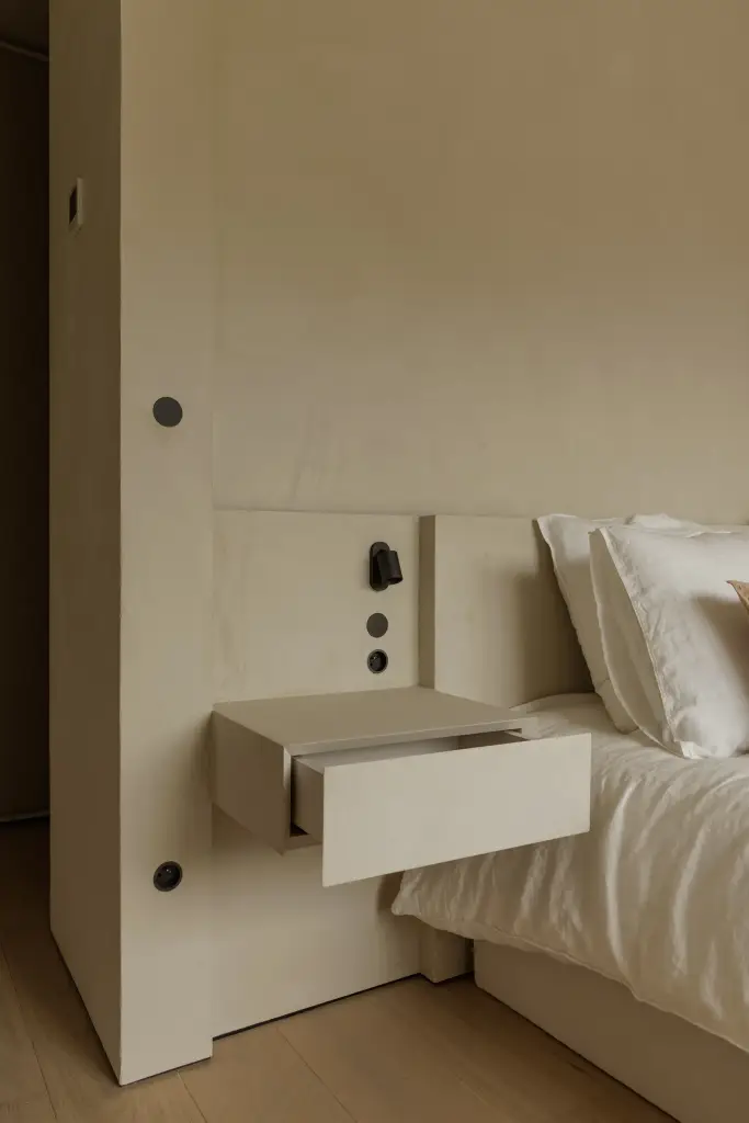 Zwevend nachtkastje met lade en stopcontacten naast het bed, Villarenovatie in Knokke, interieur Laura Calleeuw