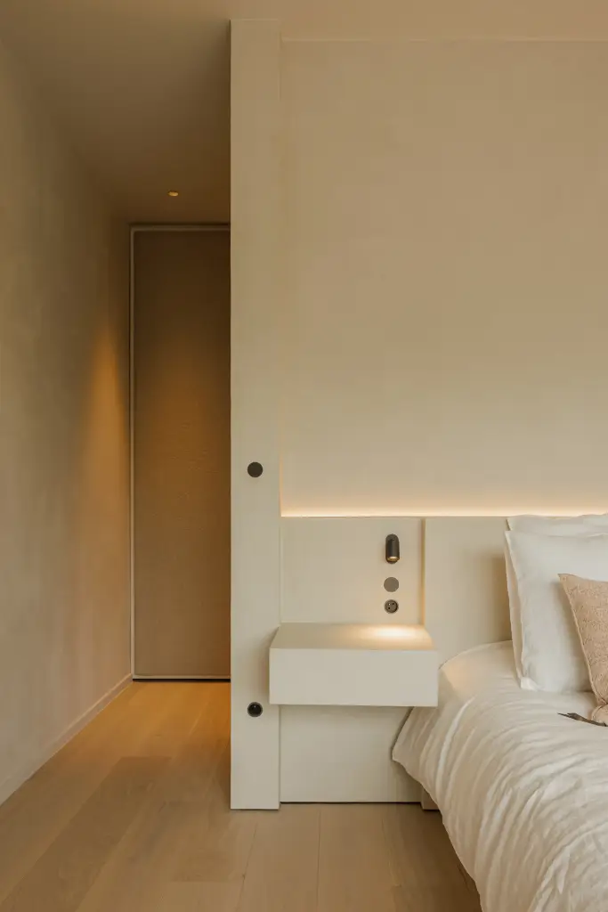 Slaapkamer met hoofdbord met lichtlijn, zwevend nachtkastje en eikenhouten parket, Villarenovatie in Knokke, interieur Laura Calleeuw