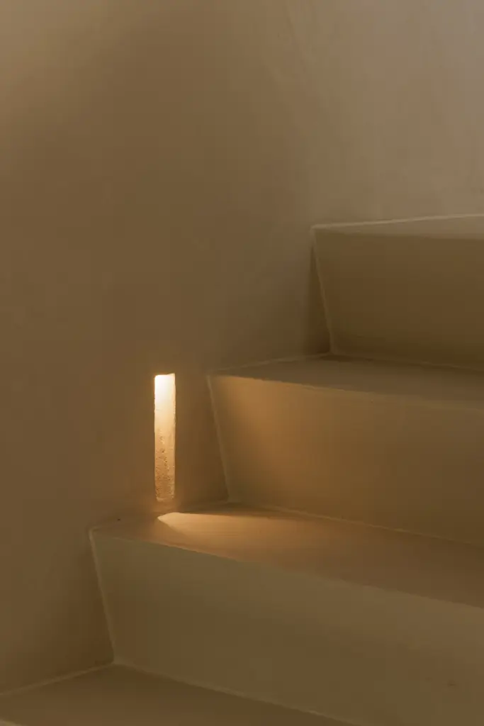 Gepleisterde trap met een ingewerkt lichtpunt in de zijwand, Villarenovatie in Knokke, interieur Laura Calleeuw