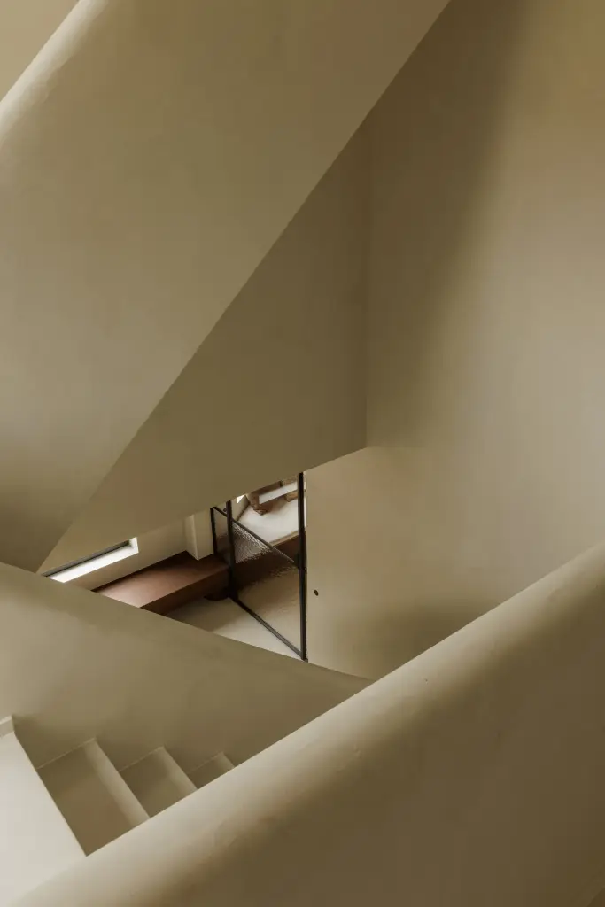 Trappenhuis met gepleisterde trap en vlakke deur, Villarenovatie in Knokke, interieur Laura Calleeuw