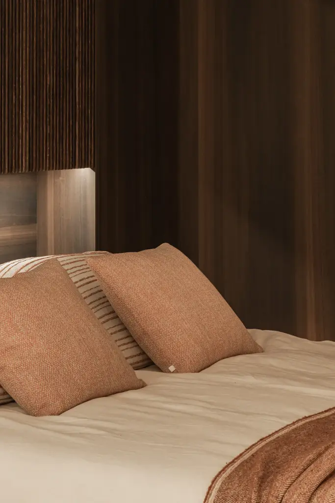 Bed met terracotta kussens en een plaid, Penthouse in Kortrijk, interieur Laura Calleeuw