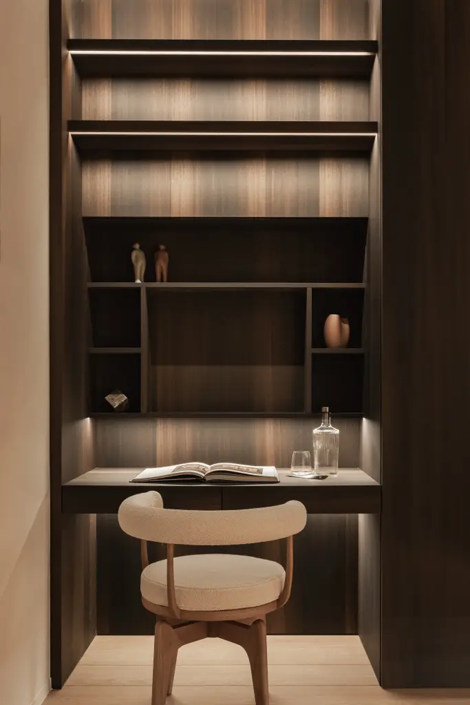 Bureaunis in notelaar met verlichte planken, ronde stoel en een open boek, Penthouse in Kortrijk, interieur Laura Calleeuw