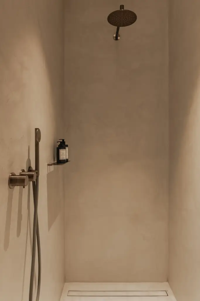 Douche in kalkpleister met koperen regendouche en handdouche, Penthouse in Kortrijk, interieur Laura Calleeuw