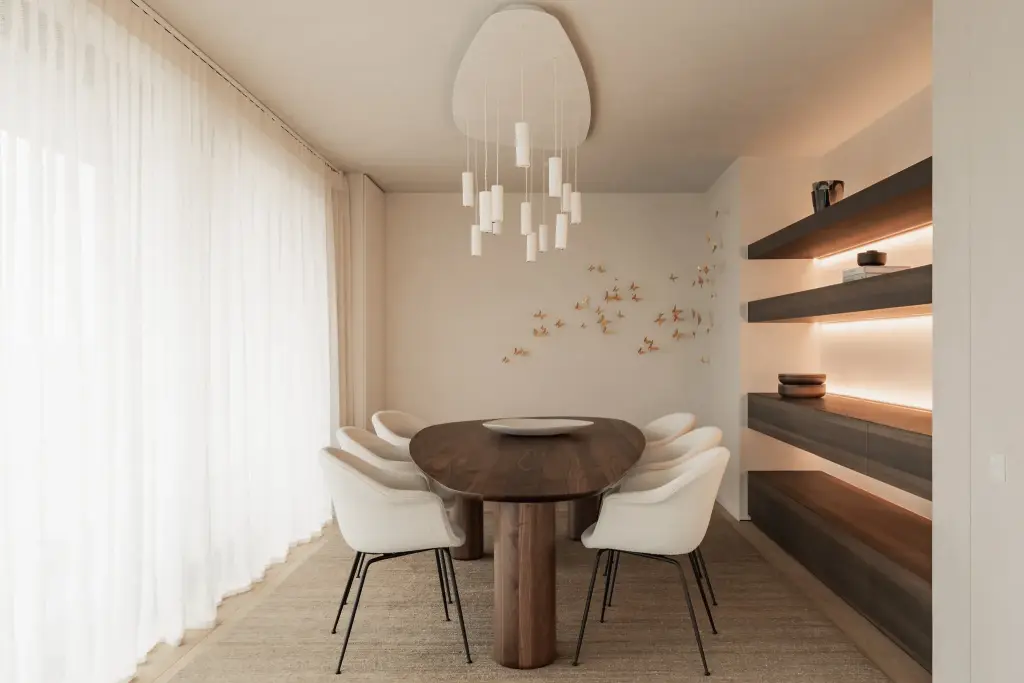 Eetkamer met hanglamp, ovale tafel en lange vitrage naast de planken, Penthouse in Kortrijk, interieur Laura Calleeuw