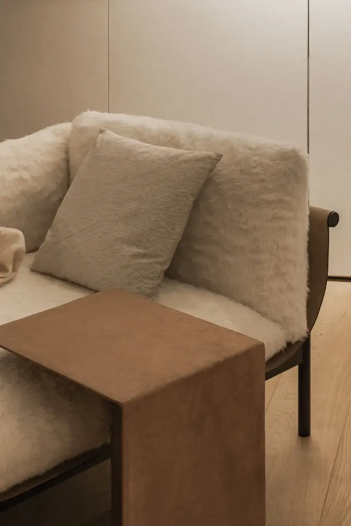 Fauteuil met zachte bekleding en een notelaren zijtafel, Penthouse in Kortrijk, interieur Laura Calleeuw